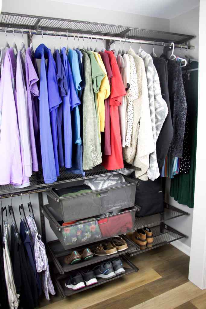 closet with rainbow color coded clothing hanging