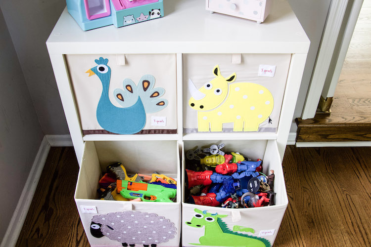 Cube organization of toys in playroom with bottom two drawers open displaying Nerf guns and action figures inside the cube organizers #playroom