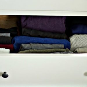 Vertically folded clothing in an open white drawer #folding