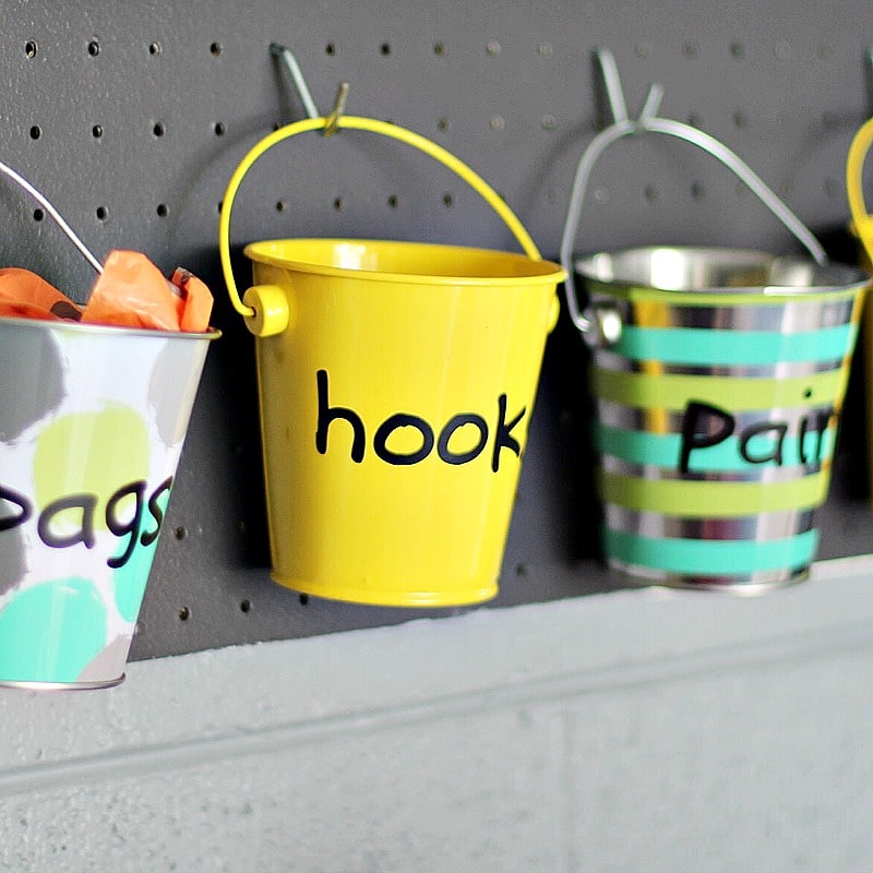garage pails on pegboard to hold hooks and dog bags