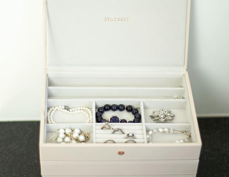 Modern organized jewelry box with bracelets, earrings, and rings. 
