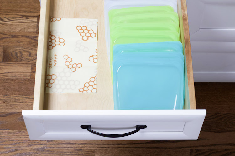 Reusable freezer bags are lined in a shallow drawer along one edge with wax paper on the other edge to demonstrate alternatives to Ziploc bags #sustainable #reusable