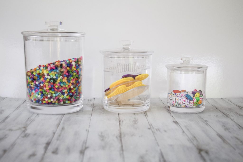 3 different size canisters that are all acrylic so you can see inside. One is full of pearler beads, one is pearler bead patterns, and one is pony beads. #organized