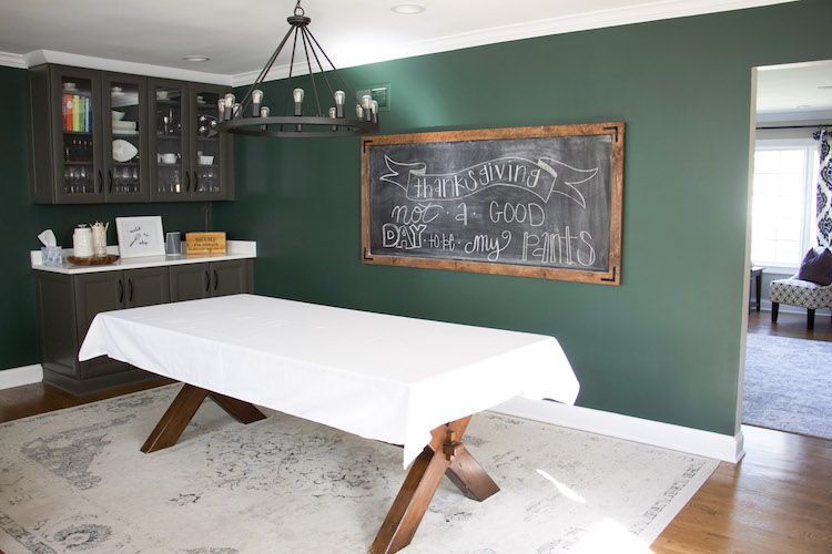 setting thanksgiving table decor with white tablecloth and chalkboard