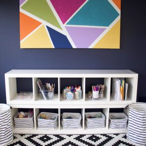 play room with colorful artwork and bins for toys