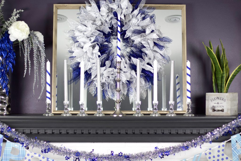 hanukkah wreath on mantel with candles as a menorah and flowers
