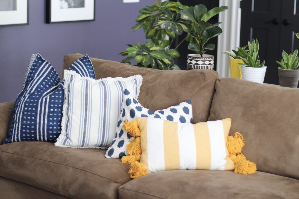 couch with blue and yellow pillows