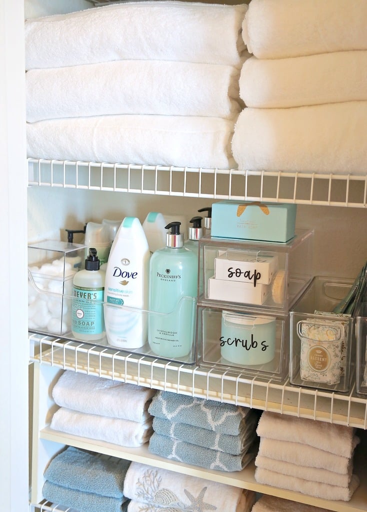 linen closet with wire shelves and clear bins with towels
