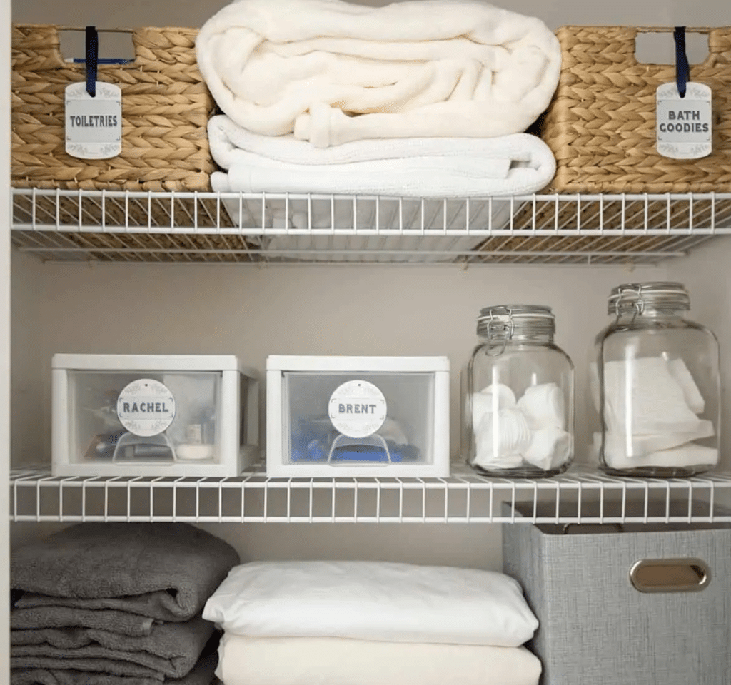linen closet with towels, baskets and jars to hold items on wire shelves