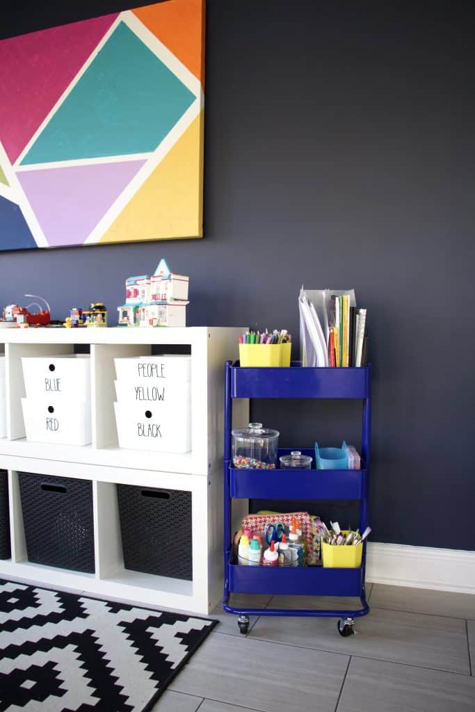 dark blue paint in playroom next to art cart and ikea kallax storage for toys