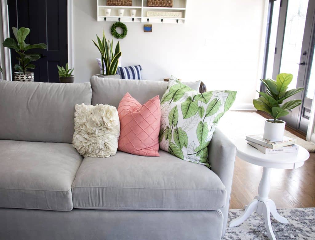 close up of pink and green chairs on grey couch