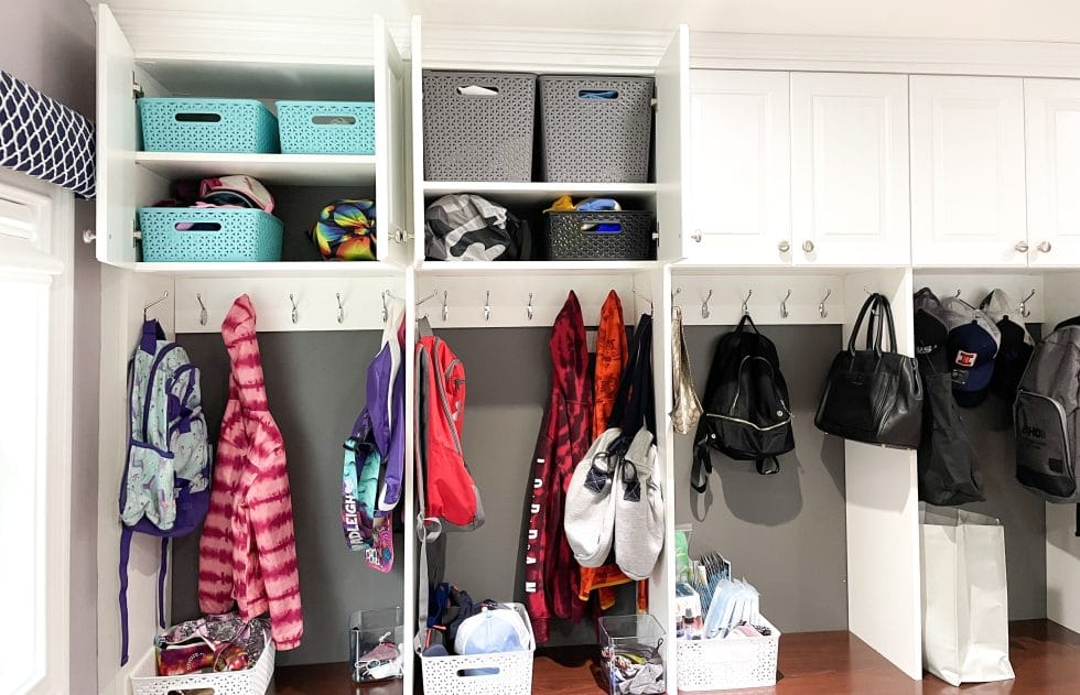 mudroom cabinets with jackets, backpacks, and bins holding off season items
