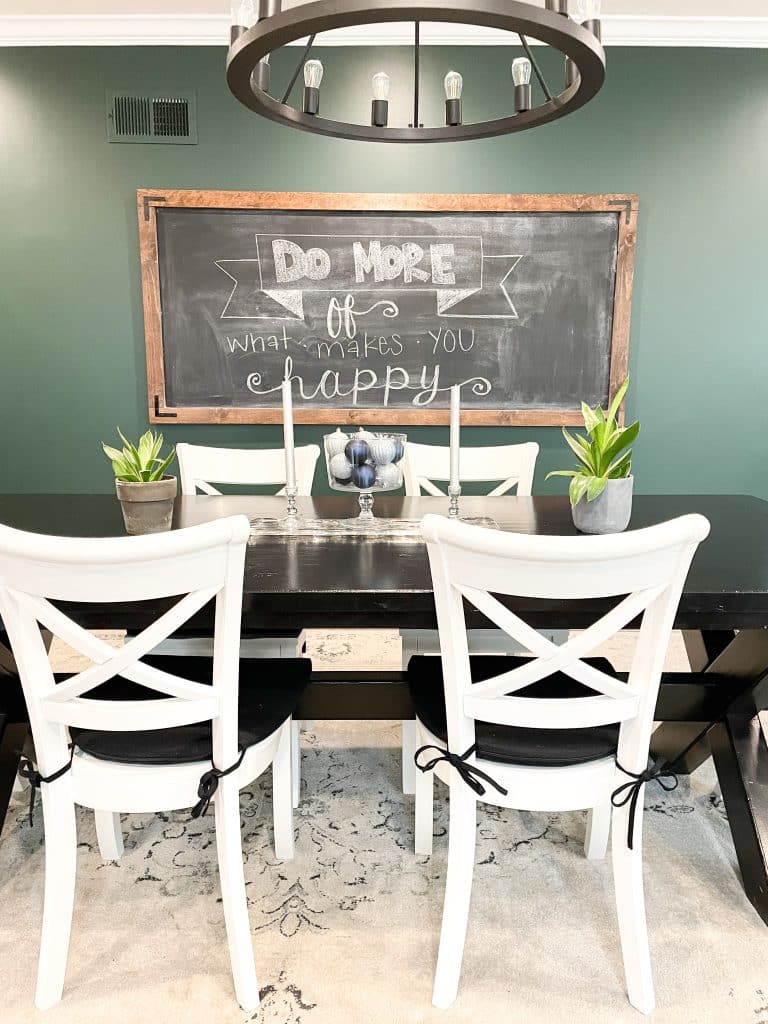 dining room with oversized chalkboard that says do more of what makes you happy 
