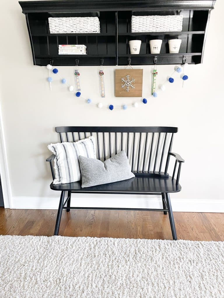 entryway with black bench and blue pillows