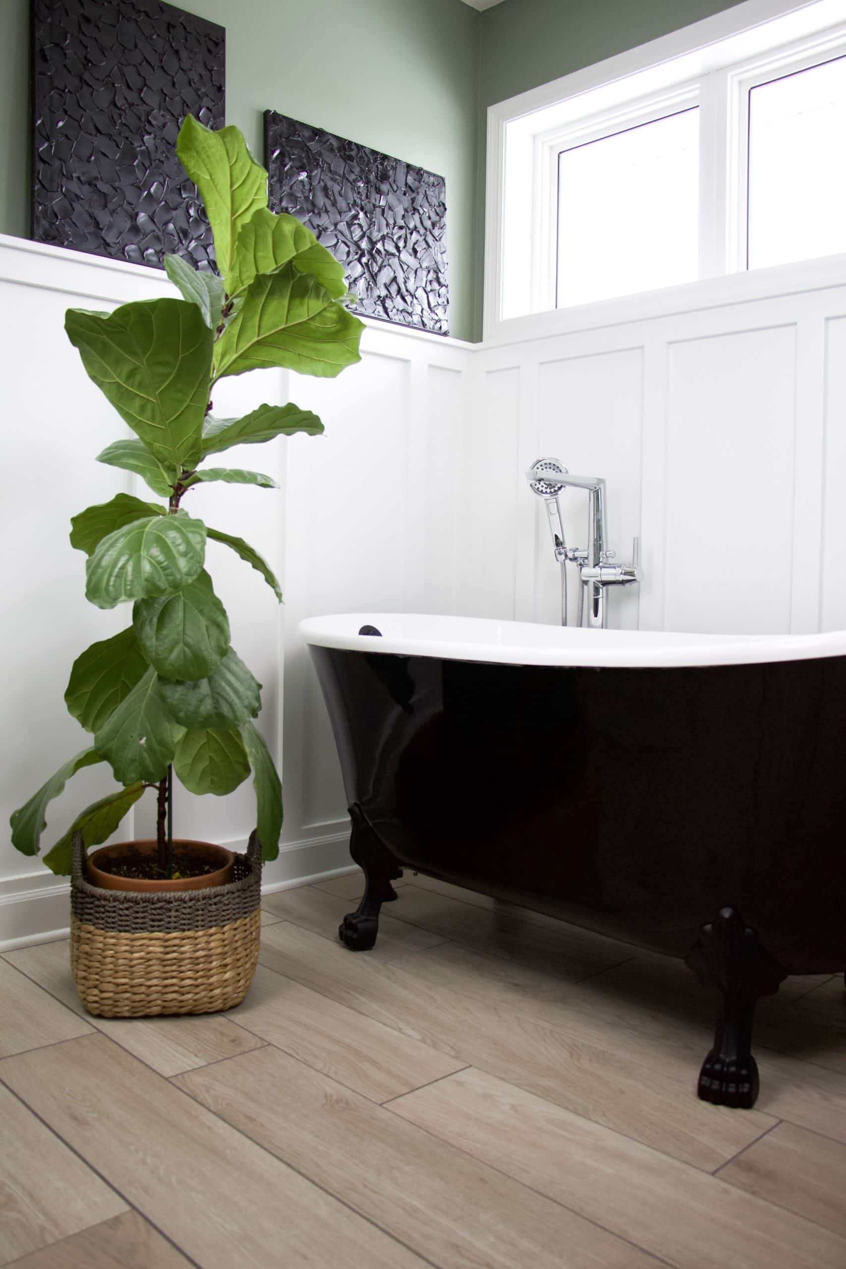 clawfoot tub with plant and tile floor
