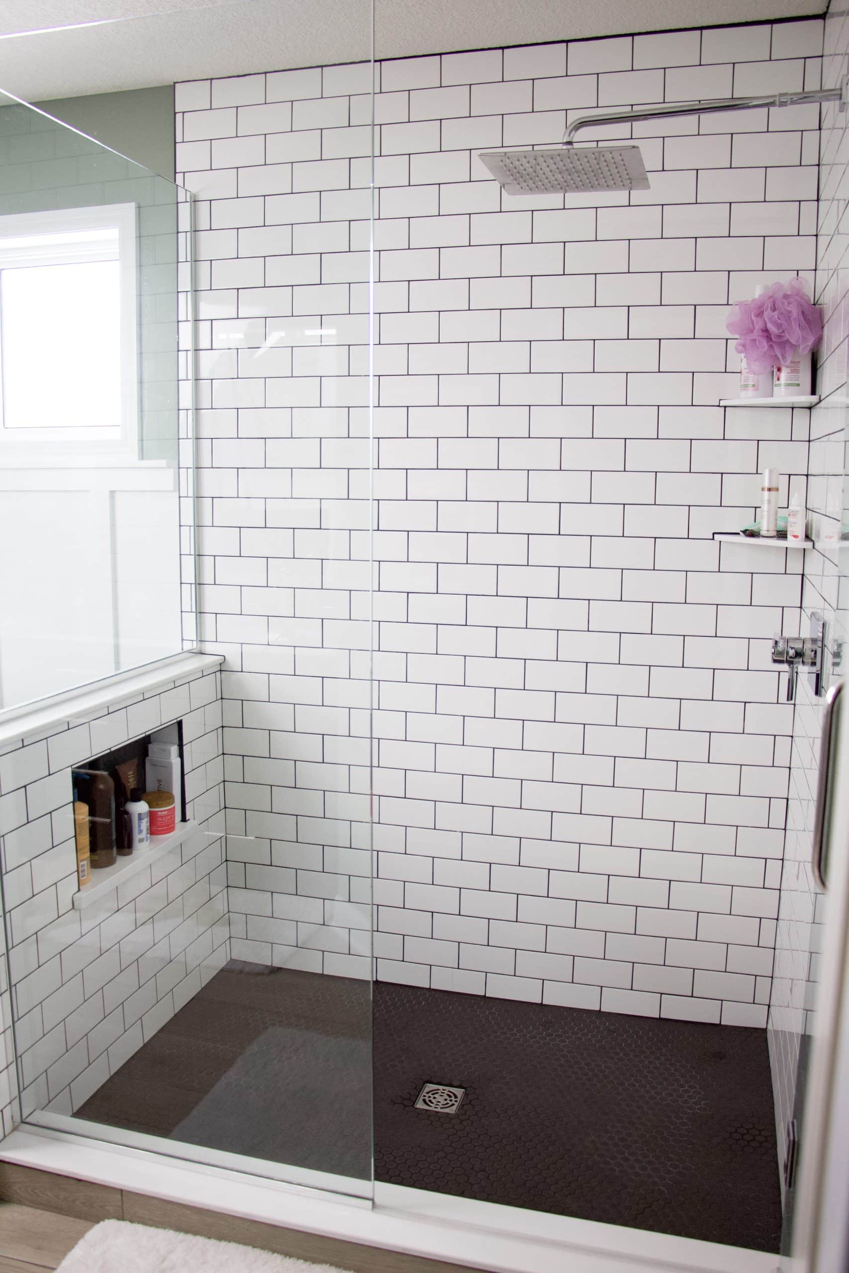 shower with subway tile and black grout