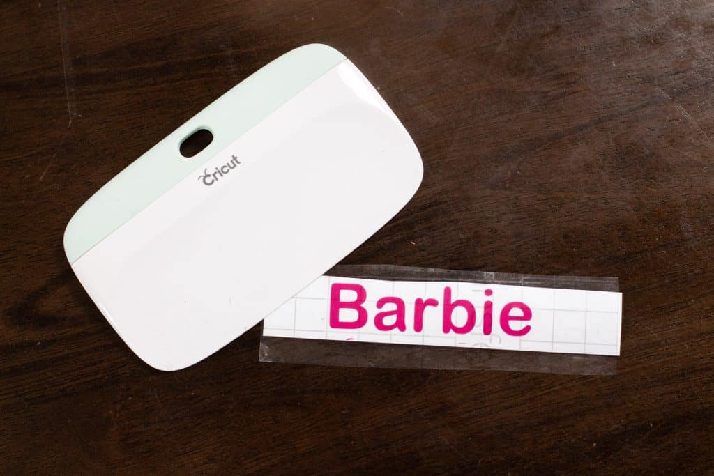 Barbie label on hot pink smart removable vinyl using the cricut joy and scrapper tool